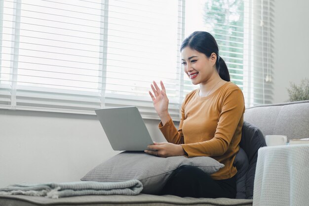 Zdjęcie wesoła kobieta wideo dzwoni online przez laptop w domu