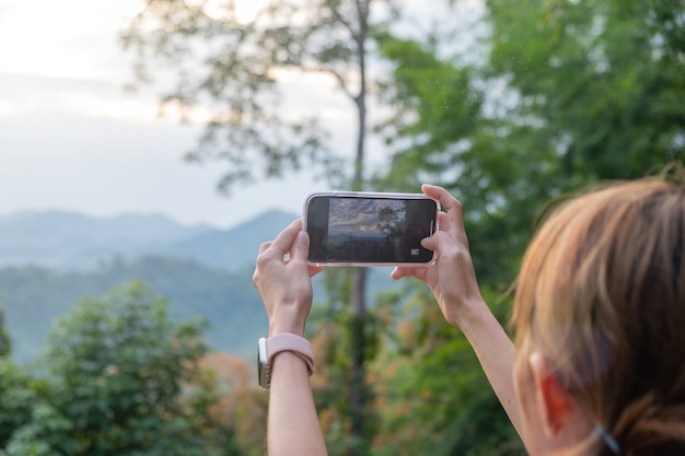 Zamknij się z młodą dziewczyną fotografowania gór