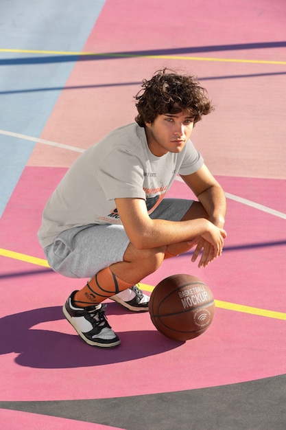 Adolescent avec basket-ball à l'extérieur sur le terrain