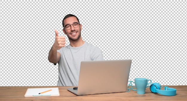 Jovem feliz fazendo um gesto bem sentado em sua mesa