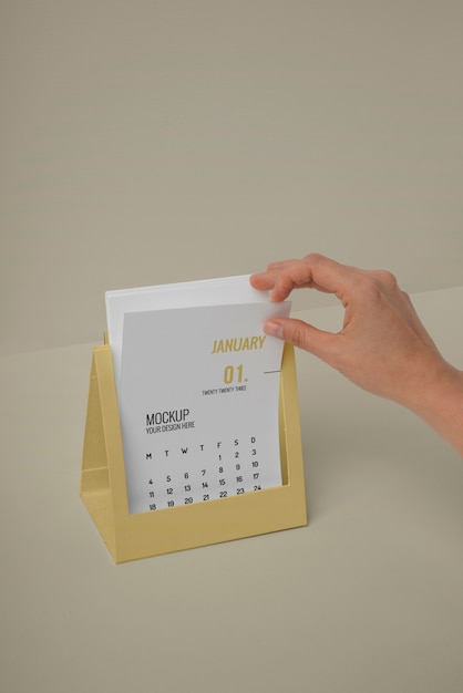 Mão segurando maquete de calendário