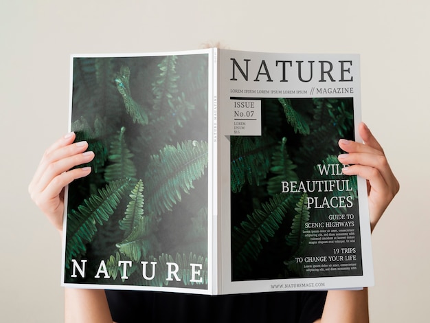 Womans main tenant un magazine de la nature maquette