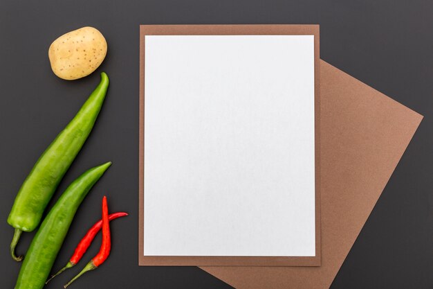 Bovenaanzicht van blanco menu papier met paprika en aardappel