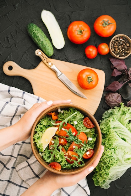 Gratis foto de holdingskom van de vrouw met plantaardige salade