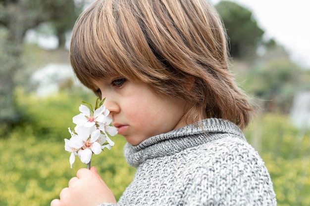 De ruikende bloem van de jongen