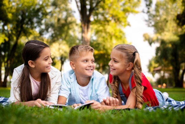 Drie schattige kinderen liggend op een deken