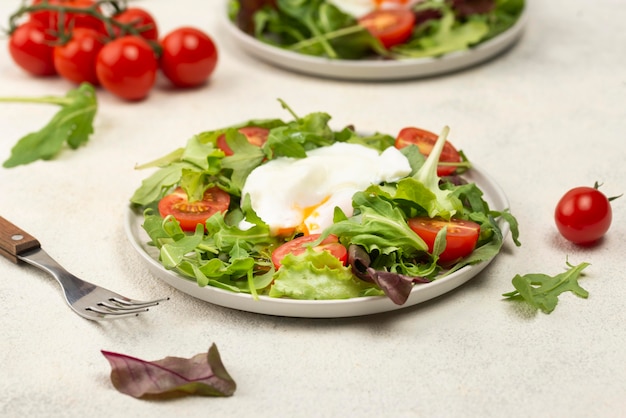 Gratis foto hoge hoeksalade met tomaten en gebakken ei