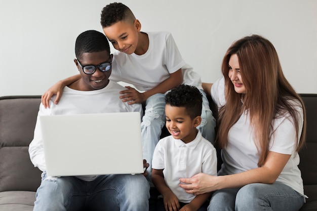 Multiculturele familie die op laptop kijkt