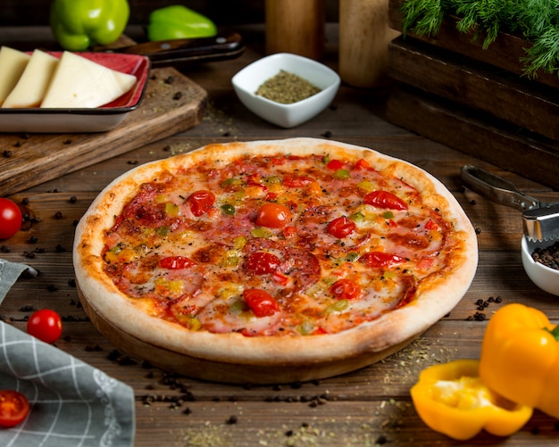 Gratis foto pepperoni pizza met tomaten paprika kruiden en kaas