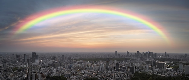 Gratis Foto regenboog in de lucht met zicht op de stad