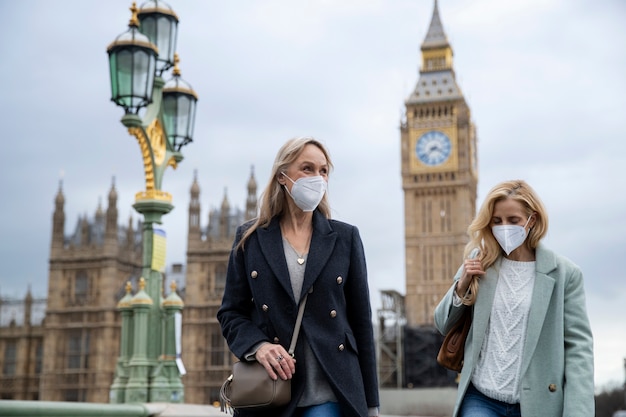 Gratis Foto toeristen die de stad bezoeken en een reismasker dragen