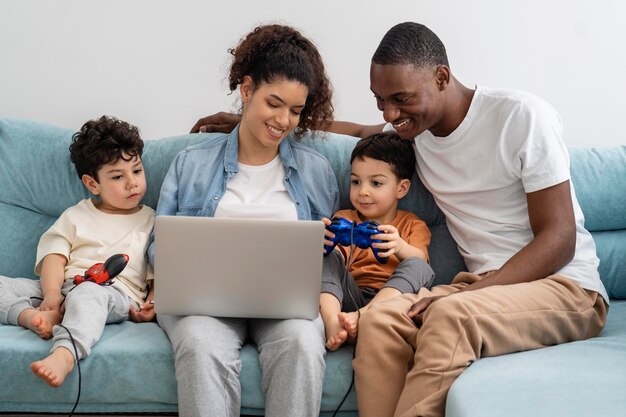 Zwarte en gelukkige familie kijken naar iets op laptop en lachen