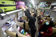 A passenger arranges his luggage on the Kertajaya train, serving the Jakarta–Surabaya route, at Senen Station in Jakarta on Oct. 27. Many people chose to travel during their extended holiday despite the risk of contracting the coronavirus. JP/Wendra Ajistyatama