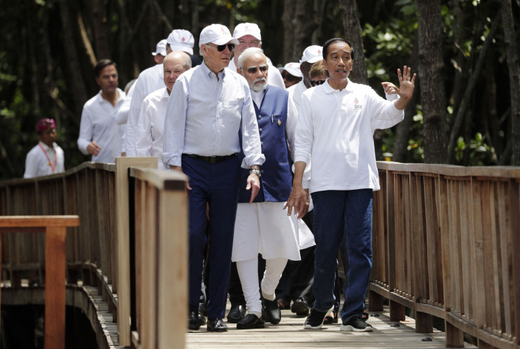 President Joko “Jokowi” Widodo (right) gestures as United States President Joe Biden (front, left), German Chancellor Olaf Scholz (back, left), Indian Prime Minister Narendra Modi (back, center) and other leaders walk together during a tree planting event at the Taman Hutan Raya Ngurah Rai Mangrove Forest, on the sidelines of the G20 summit meeting in Nusa Dua, Bali, on November 16, 2022.