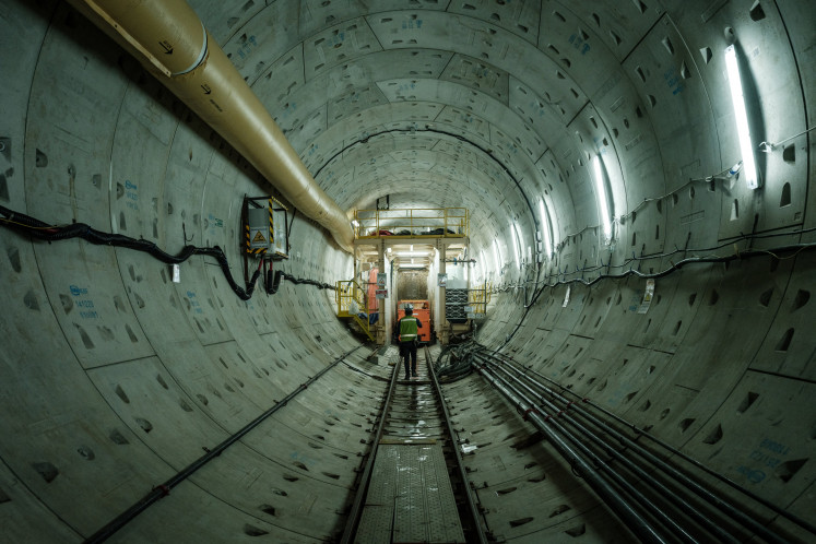 A worker walks on May 7, 2024, at the end of a tunnel construction site for the Jakarta MRT in front of a tunnel boring machine. Phase 2 of the project will extend the current line to the north with a loan from the Japan International Cooperation Agency (JICA).