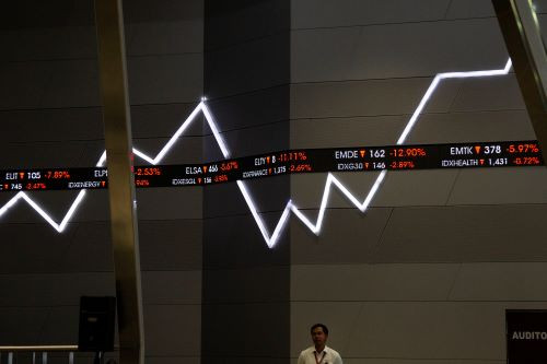 Ups and downs: An employee walks past a giant monitor showing the fluctuations of the Indonesia Stock Exchange (IDX) Composite at the IDX building in Jakarta on Aug. 5, 2024.