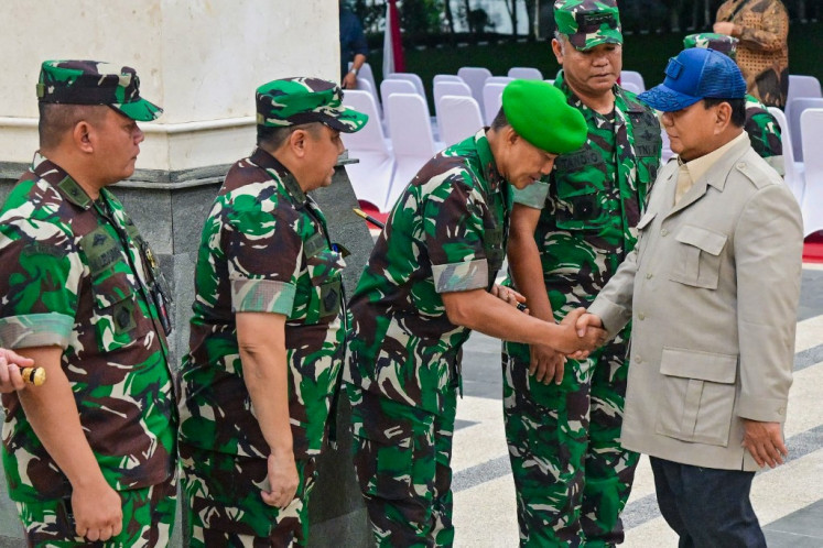 Firm shake: President Prabowo Subianto (right) greets army officers as he arrives at the military academy to attend their cabinet retreat in Magelang, Central Java, on Oct. 24.