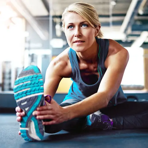 photo of 30s woman stretching in gym