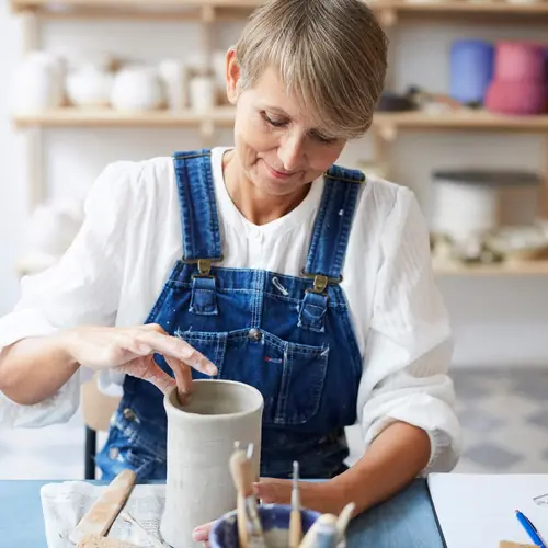 photo of woman spinning pottery