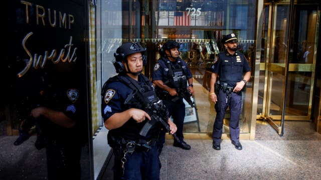 Officers armed with rifles stand outside Trump Tower.