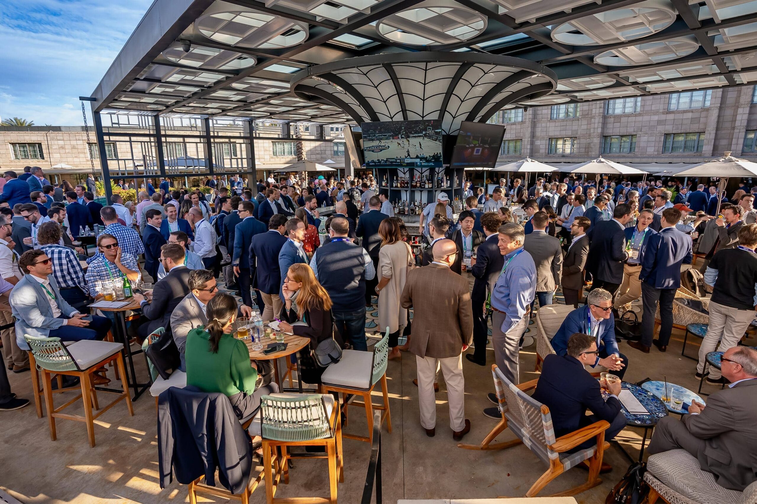 Business professionals gathered outdoors around the Spire Bar, networking and chatting