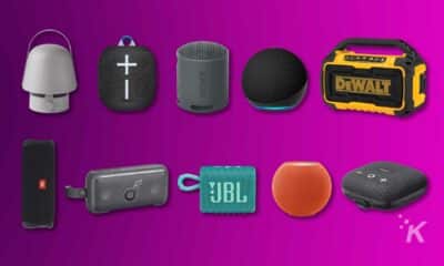 Variety of portable wireless speakers on purple background.