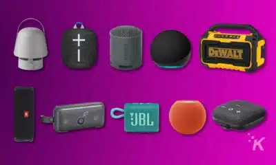 Variety of portable wireless speakers on purple background.