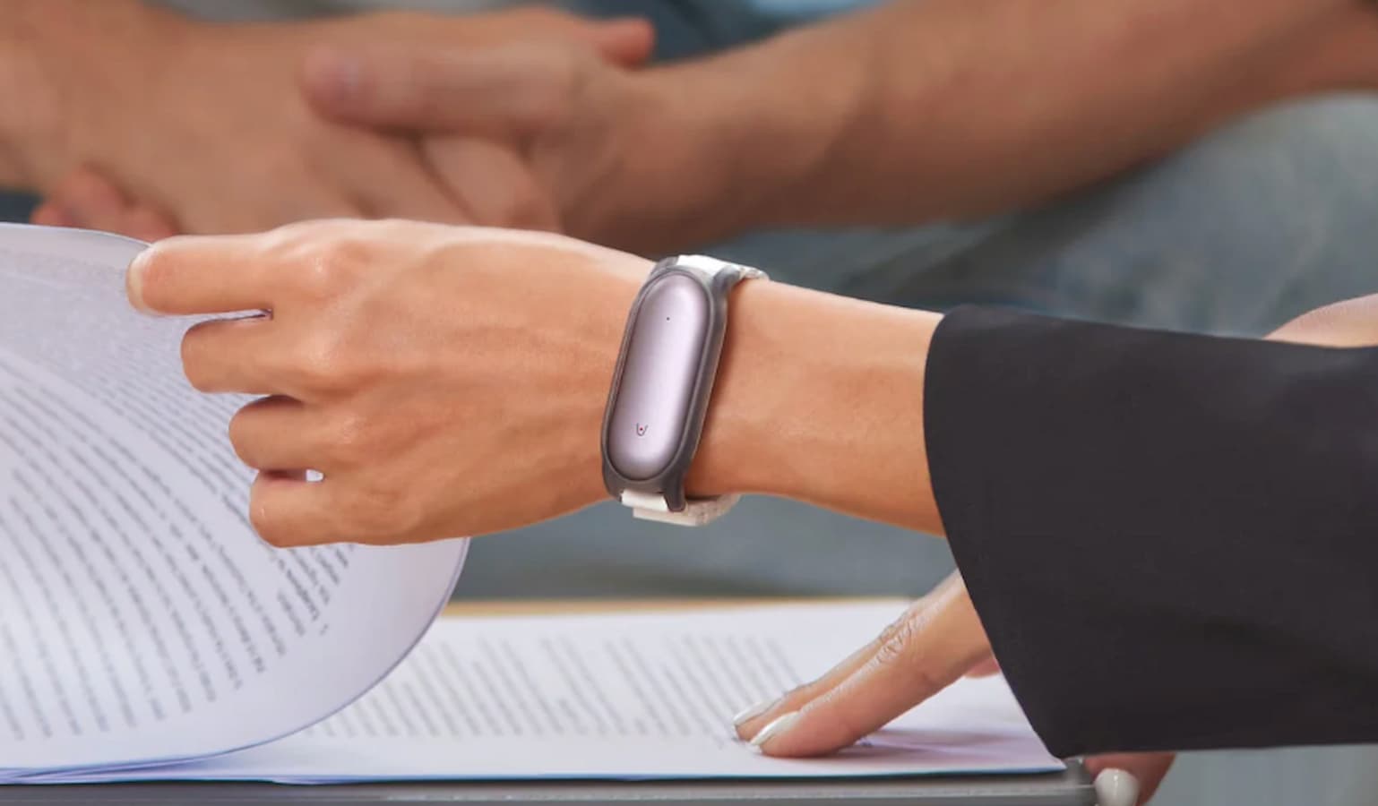 Person wearing smartwatch and reading documents.