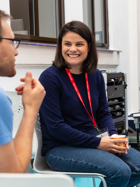 A woman smiling while discussing something with a man