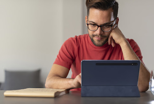 pria berbaju merah sedang melihat tablet