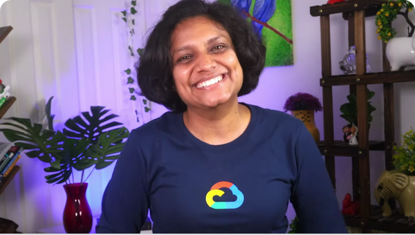 Perempuan tersenyum ke kamera, dia mengenakan kaos Google Cloud lengan panjang.