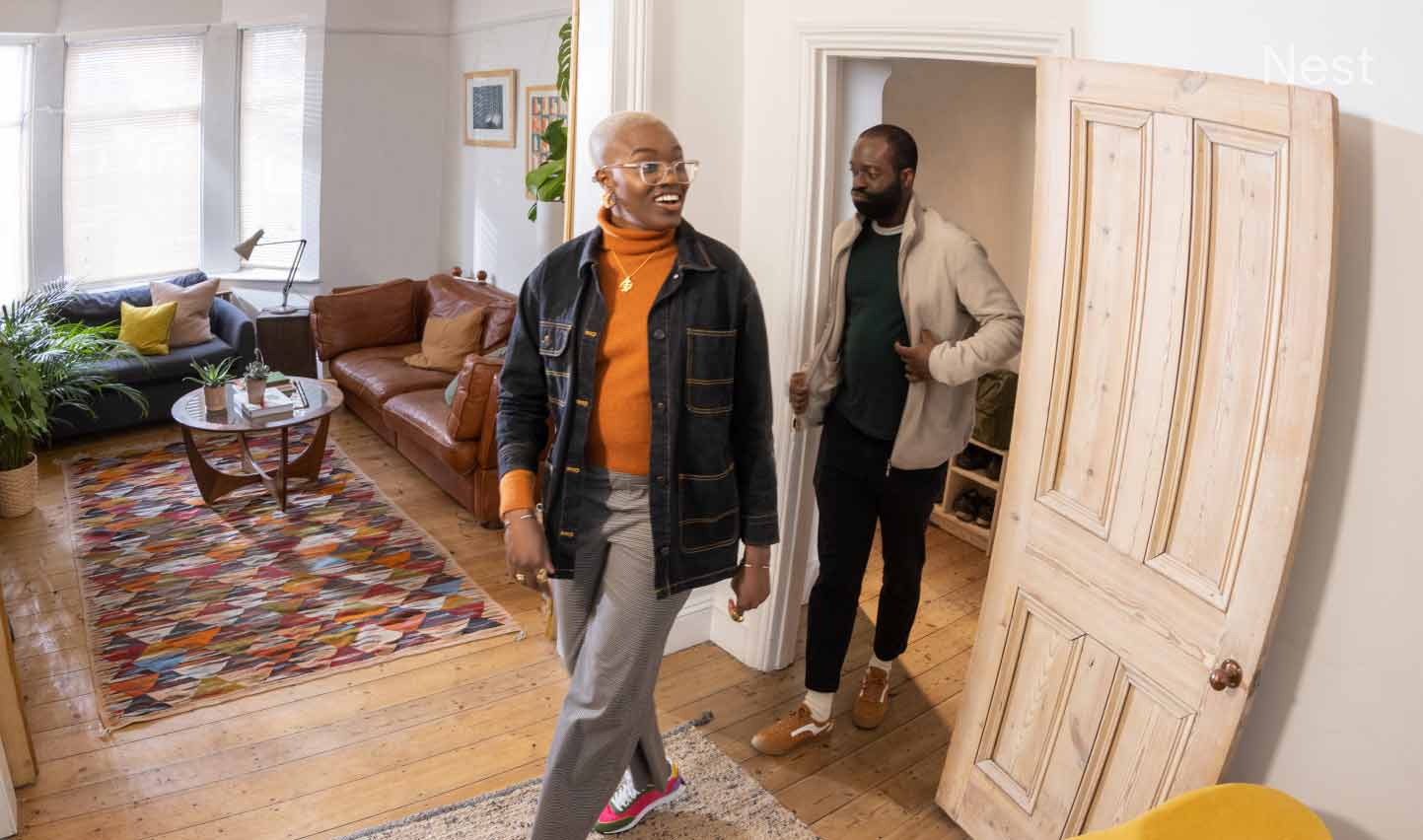 A couple walks into a living room of a residential home.