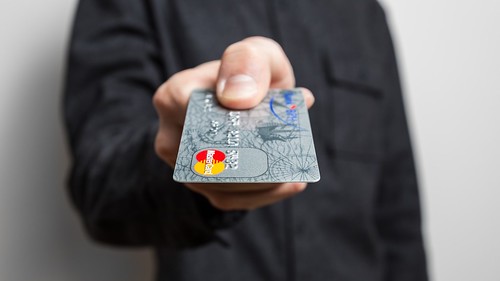 Holding credit card | by cafecredit