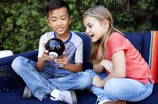 Two children looking into Magic 8 ball