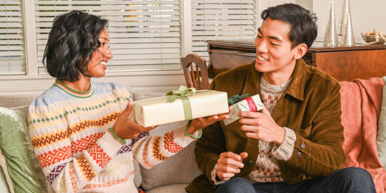 Woman passing a gift to a man in a living room