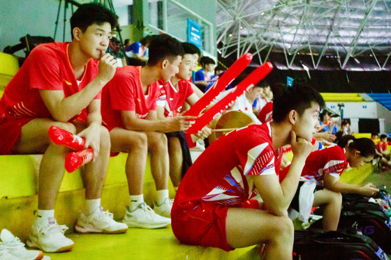 Players sit in the stands as they watch their teammates