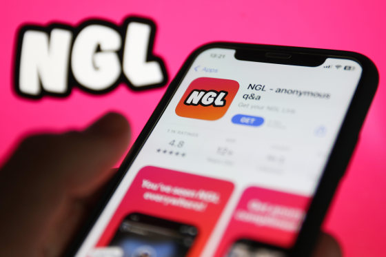 NGL on App Store displayed on a phone screen and NGL website displayed on a screen in the background 