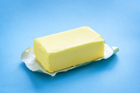 Single butter stick on blue background.