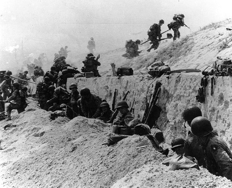 U.S. soldiers of the 8th Infantry Regiment, 4th Infantry Division, move over the Utah Beach seawall during the invasion.