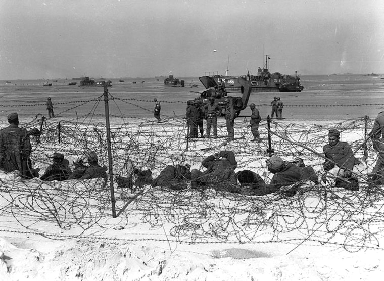 Prisoners of war sit inside a specially constructed enclosure on Utah Beach.