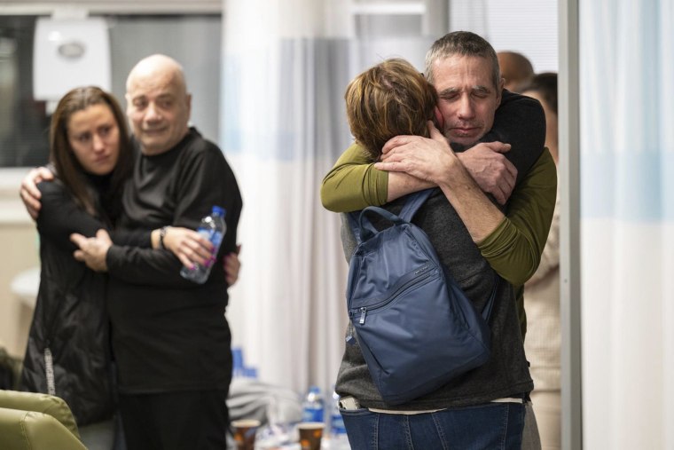 Hostages Fernando Simon Marman, right, and Luis Har, second from left, hug relatives after being rescued from captivity in the Gaza Strip, at the Sheba Medical Center in Ramat Gan, Israel, Monday, Feb. 12, 2024. 