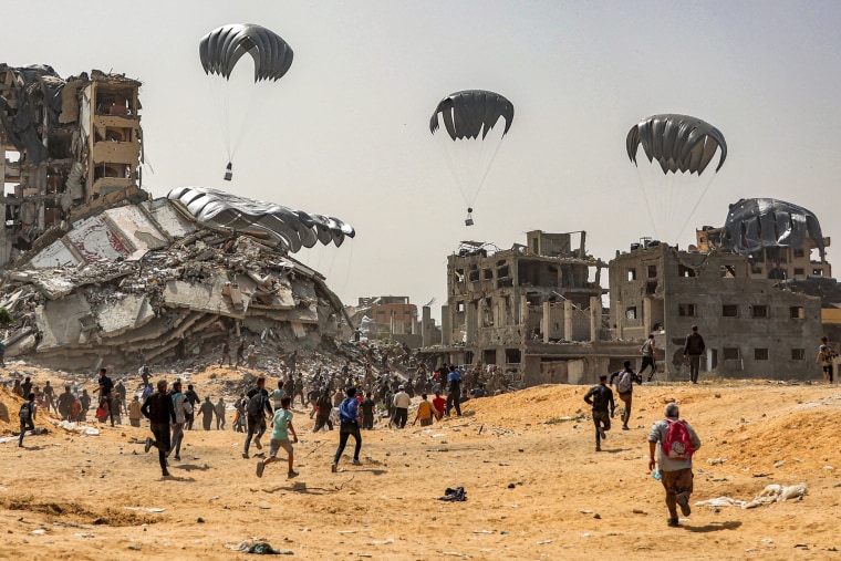 People rush to humanitarian aid packages dropped over the northern Gaza Strip on April 23, 2024.