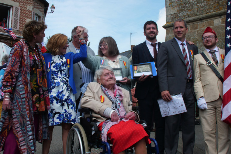 Nicole and Mireille hold hands aboved Marie Bastien at a ceremony for Paul Chaufty. 