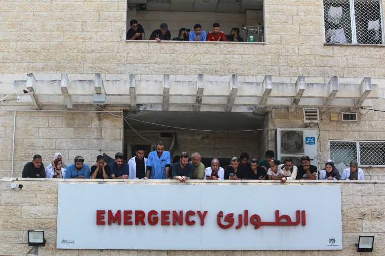 Medics and nurses watch for the arrival of patients from two balconies on top of one another