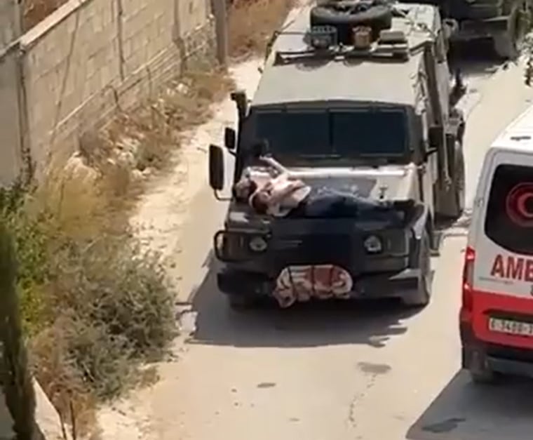 A still image from a video showing a Palestinian man tied to the hood of an Israeli military vehicle in the occupied West Bank.