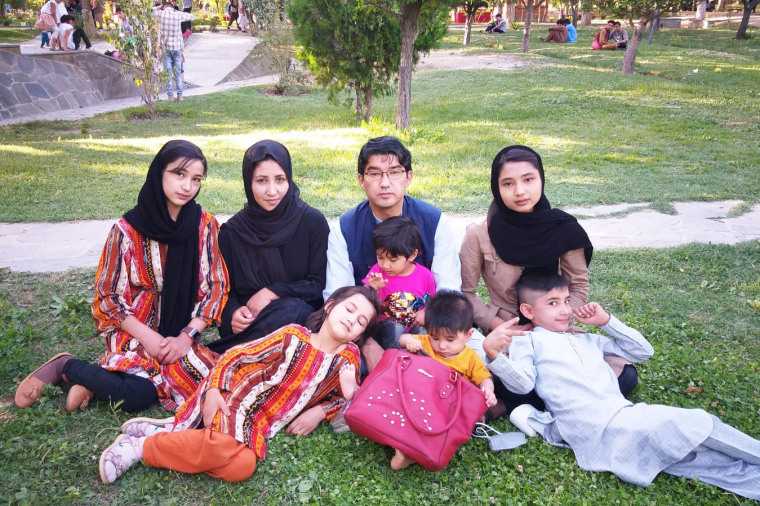 The family poses for a photo on the grass