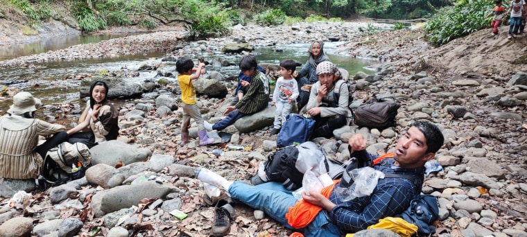 Zahra Shahnoory and her family sit on rocks at the Darien Gap