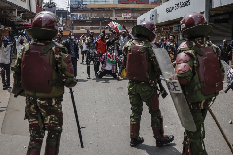 A group of demonstrators wave Kenyan flags in front of Kenyan anti riot police officers during an anti-government demonstration called following nationwide deadly protests over tax hikes and a controversial now-withdrawn tax bill in downtown Nairobi, on July 2, 2024. 