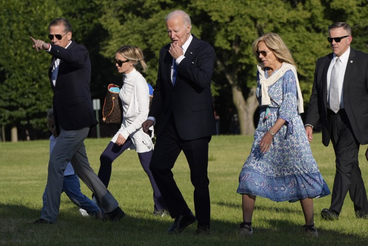 President Joe Biden, center, walks with his family on the grass at Fort Lesley J. McNair in Washington, D.C.