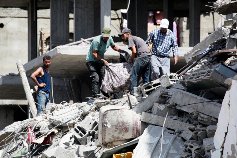 Palestinians recover belongings from the rubble.